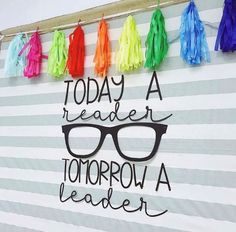 a sign that reads today a reader tomorrow a leader with tassels hanging from it