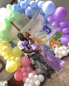 two people are standing in front of balloons