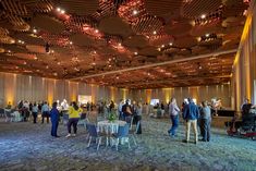 a large room filled with people standing and sitting