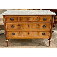 an old wooden dresser with marble top