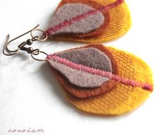 two pairs of earrings made out of knitted fabric with metal hooks on white background