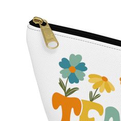 a white zippered pouch with colorful flowers and the word tea on it's side