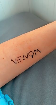 a person with a tattoo on their arm that says,'neon'in cursive writing