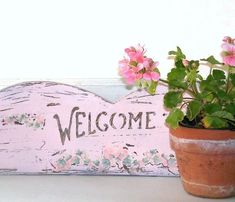 a potted plant sitting next to a welcome sign