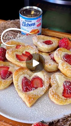 some heart shaped pastries on a plate with strawberries