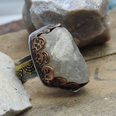 "A raw chunk of natural quartz, found in the desert here in Southern California, has been set in a copper skull bezel onto a sterling silver ring. Spiderwebs also adorn the band of the ring.  The ring has been oxidized and brushed to bring out the details in the copper skull bezel and the spiderwebs.  The ring is a size 8. The stone setting is about 1-1/4\" long by just under 1\" wide and the band is about 3/8\" thick." Bohemian Rings With Raw Stone For Healing, Bohemian Raw Stone Rings For Healing, Handmade Bohemian Skull Ring As Gift, Bohemian Raw Stone Healing Rings, Handmade Bohemian Skull Ring For Gift, Stone Setting, In The Desert, The Desert, Stone Settings