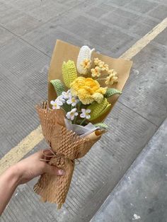 someone is holding a bouquet of flowers on the street