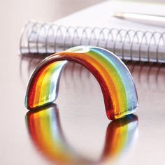 a rainbow ring sitting on top of a table next to a notebook