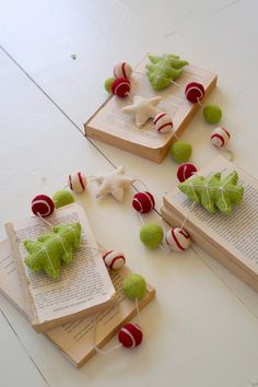 three books with christmas decorations on them sitting on a table next to some candy canes