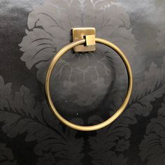 a close up of a towel ring on a black and gold wallpapered surface