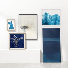 an art gallery with blue and white paintings on the wall