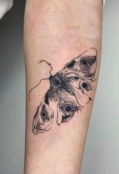 a black and white butterfly tattoo on the leg