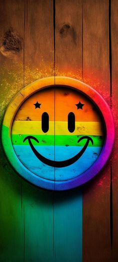 a smiley face painted on the side of a wooden door with stars and rainbow colors