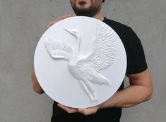 a man holding a white plate with a bird on it