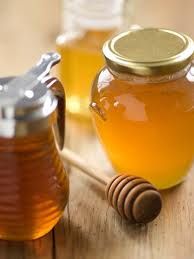 a jar of honey sitting on top of a wooden table