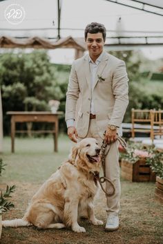 a man standing next to a golden retriever on top of a grass covered field