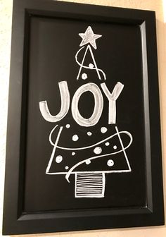 a chalk drawing of a christmas tree with the word joy written on it in white