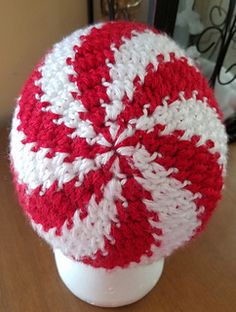 a red and white crocheted hat sitting on top of a table