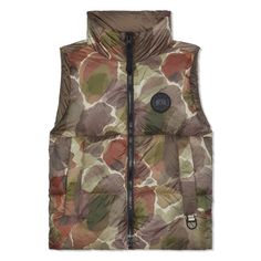 This variation of the Everett Vest comes in an exclusive print inspired by formations of topographical landscapes. It's made with highly durable and soft Recycled Feather-Light Ripstop Shiny fabric and designed for all-season wear. The classic silhouette is modernized with an all-black trims package and features like a D-ring to attach gloves and other necessities on the go, making it excellent for travel and unpredictable conditions. Hem features interior drawcord to customize fit and trap heat towards the body Two exterior pockets: zippered hand pockets Two interior pockets: one zippered security pocket, one mesh drop-in pocket Fill: 750 Fill Power Responsibly Sourced Duck Down. TEI 1 rating.   Part of the Botanical Capsule.   Sku: 2616MBP-1550 Canada Goose Logo, Canada Goose Mens, Shiny Fabric, Lightweight Quilt, Mens Luxury Fashion, Down Vest, Botanical Print, Duck Down, Brand Tags