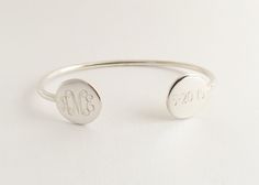 This monogram silver or gold colored cuff bracelet makes a beautiful present for your wife, mother or friend (or for yourself!). The engraving on both discs is included in the price. Commemorate a special day putting a monogram on one side and date on the other. Great for weddings, graduation, birthdays etc. Specify your font choice and initials or monogram for the disc. They are also perfect for for bridesmaids presents. Comes in nice kraft gift box. Bracelet- Gold Finish or Silver Finish How t Personalized Silver Bracelet With Initials, Personalized Silver Bracelets With Initials, Adjustable Engraved Name Bracelet For Bridesmaid Gift, Personalized Round Bracelets With Engraving Option, Personalized Engraved Bracelet As A Gift, Personalized Engraved Round Bracelets, Round Bracelets With Engraving Option For Personalized Gifts, Classic Adjustable Name Bracelet, Silver Initials Bracelets For Wedding