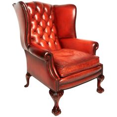 a red leather chair with nail polishing on the armrests and foot rest