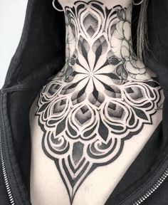 the back of a woman's neck is covered in black and white tattoos,