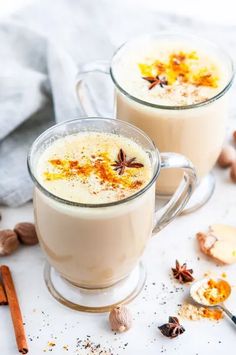 two mugs filled with hot chocolate and spices