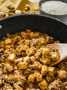 a pan filled with rice and tofu next to other ingredients