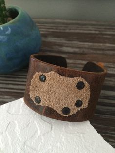 "This unique multi-color cuff bracelet is made of natural, rustic cowhide leather. I riveted a super soft piece of natural suede to the cuff for interest and detail. The riveted suede creates a \"pocket\" that will hold feathers or anything else your mind can imagine. I personally have a cuff in this style and I wear it with a feather. This cuff is ready to ship and will arrive attractively packaged and ready for gifting or for keeps. MEASUREMENTS & SPECIFICS: SIZE: one size - fits most men Handmade Western Brown Bracelets, Handmade Western Brown Bracelet, Handmade Western Style Brown Bracelet, Hand Tooled Brown Leather Bracelets, Distressed Brown Leather Bracelets As Gift, Adjustable Brown Western Cuff Bracelet, Brown Leather Hand-tooled Bracelets, Handmade Western Brown Cuff Bracelet, Rugged Leather Bracelets