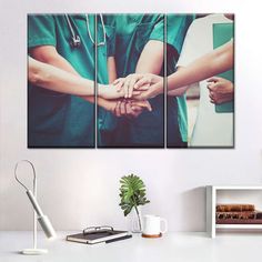 three doctors holding hands together in the middle of a room with a white table and chair