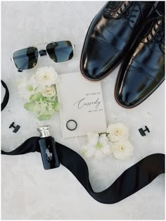 a pair of black shoes and sunglasses next to a card