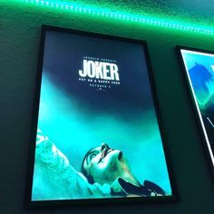 two movie posters hanging on the wall next to each other in a room with green lighting