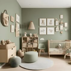 a baby's room with green walls and pictures on the wall