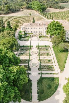 an aerial view of a large white house surrounded by trees