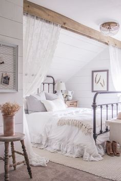 a bedroom with white bedding and curtains