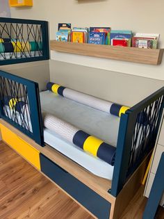 a child's bed with blue, yellow and white furniture