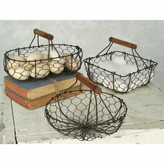 two wire baskets filled with eggs sitting on top of a table next to an open book