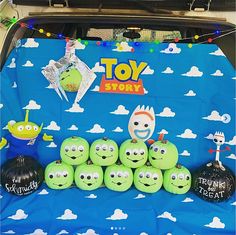 the back of a car with toy story characters on it's trunk and inflatable balloons