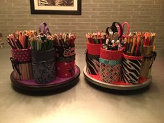 two cups with pens and pencils in them