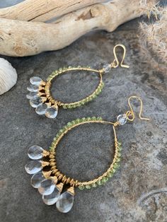 Beautiful boho style handcrafted gemstone hoop earrings .. crafted with hand forged non tarnish gold tone hoop frames with have wire wrapped Peridot gemstones accented with gorgeous faceted hand wire wrapped Crystal Vlear Quartz gemstones . These super stunners measure 3.5 inches in length and have beautiful movement . Bohemian Hand Wrapped Small Hoop Jewelry, Bohemian 14k Gold Filled Wire Wrapped Jewelry, Bohemian 14k Gold Filled Hoop Earrings, Gemstone Beads Hoop Earrings Gift, Unique Wire Wrapped Dangle Hoop Earrings, Bohemian Wire Wrapped Hoop Jewelry, Bohemian Teardrop Earrings With Gemstone Accents, Bohemian Gold Crystal Earrings With Gemstone, Bohemian Style Wire Wrapped Dangle Hoop Earrings