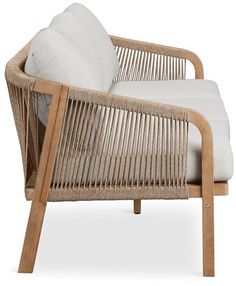 a wicker lounge chair with white pillows on the armrests and seat cushion