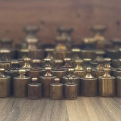 many brass knobs are placed on a wooden surface