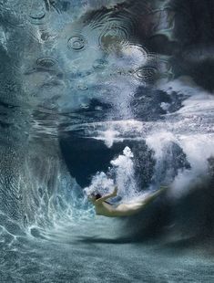 a man is swimming in the water with his hands on his hips and looking up at him