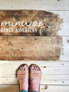 the feet of a person standing in front of a wooden sign that says pineapple early american