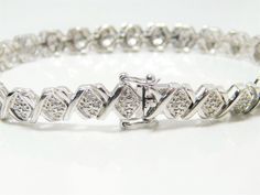 Silver bracelet sterling silver tennis bracelet linked with 26 'Xs' all with 4, 1mm round diamonds totaling 96 round cut diamonds (tested with a Presidium 2 tester).  Lovely and in excellent condition.  The bracelet is marked Thailand, makers mark and 925.  Please view all photos for accurate description and condition. Thank you for shopping with Indigo. Silver Tennis Bracelet, Art Nouveau Silver, Jade Bracelet, Bracelet Sterling Silver, Jade Beads, Jewelry Maker, Vintage Bracelets, Tennis Bracelet, Round Cut Diamond