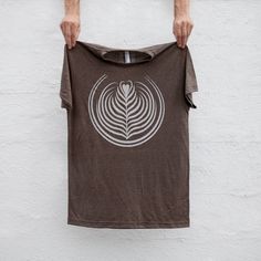 ♥ Be the latte. A tribute to my ten years as a barista, our Liquid Courage t-shirt features Tulip latte art splashed across the chest. Each is lovingly hand-printed with white water based ink onto heather brown unisex tees. Available in sizes S-2XL. FIT & SIZING: - Male model shown is 5'9 and 135lbs. He's wearing a medium - Please consult sizing chart provided in image #3 to ensure best fit - Mens / unisex tri-blend tee - True to size, but with a slim fit - Lightweight jersey blend with a durabl Coffee Shop Shirt, Barista Shirt, Barista Gift, Father Son Matching Shirts, Brew Bar, Coffee Latte Art, Heather Brown, Bakery Business, Coffee Shirt