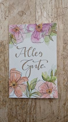 a greeting card with watercolor flowers and the words,'alco gate '