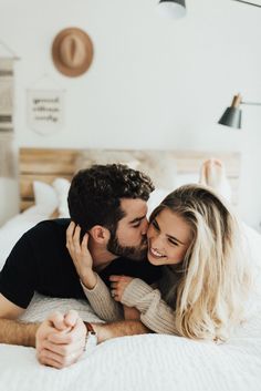 a man and woman laying on top of a bed