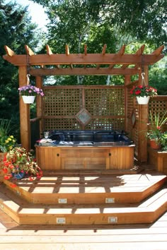 an outdoor hot tub surrounded by wooden steps and plants on the side of a deck