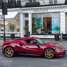 a red sports car parked in front of a store